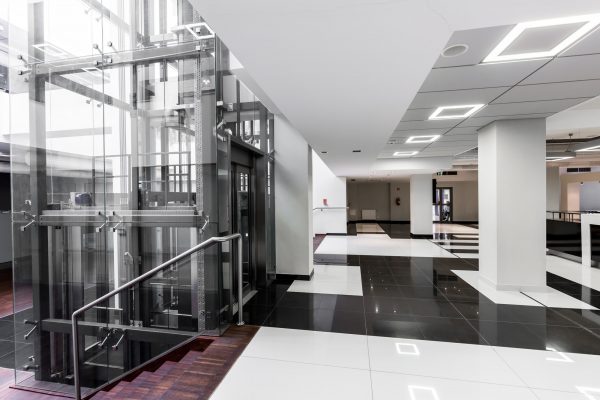 Modern hallway with glass elevator Architect